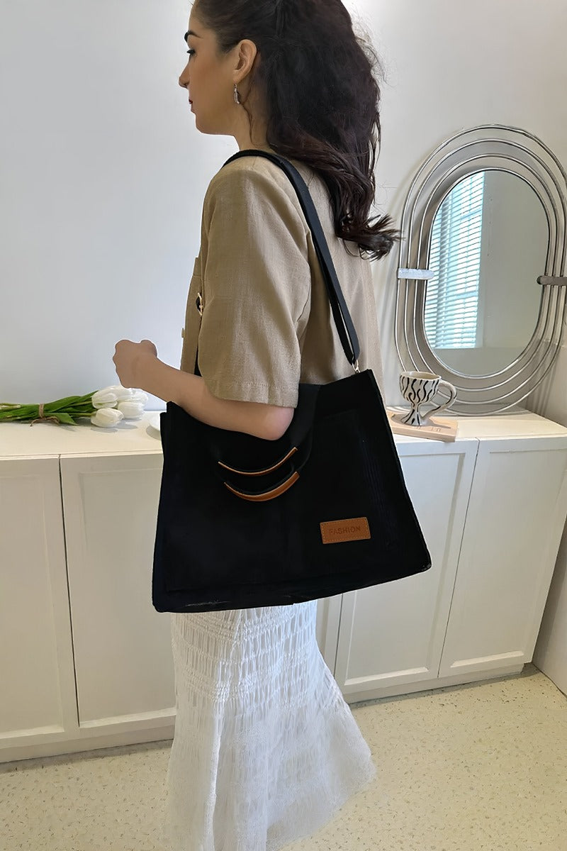 Black corduroy shoulder tote bag with soft body and boxy structure