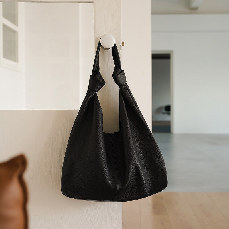 Black cowhide underarm handbag with open pocket and zipper compartments