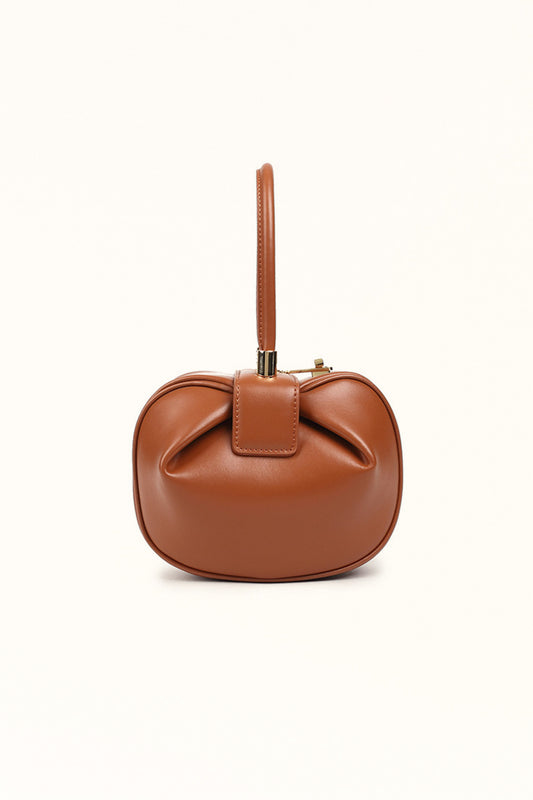 Caramel tone leather tote bag with soft finish and modern dumpling shape